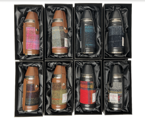 alt= a collection of hunting flasks with two different styles of leather brown and black and eight different harris tweed patterns on a white background