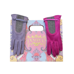 alt= a pair of gloves one pink the other purple resting on a bag with a colorful design