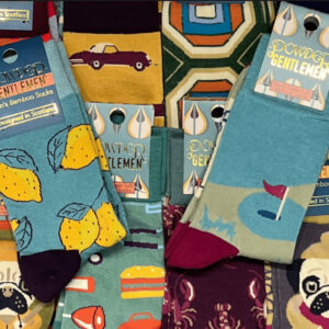 alt= a collection of colorful masculine socks with a wide variety of styles pilled on top of each other