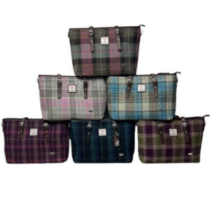 alt= collection of six harris tweed bags with varying colors on a white background