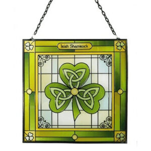 alt= a green stain glass window piece depicting a shamrock with the Celtic trinity