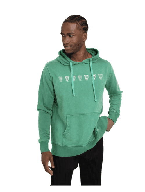 Irish man in a green Guinness Harp hoodie with Celtic knotwork and harp motifs, blending heritage style and modern comfort.