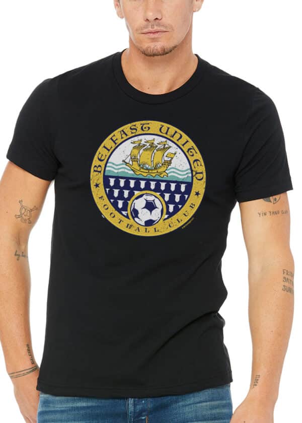 Irish man wearing a black Belfast United FC shirt with Celtic ship, stylized waves, and football crest in crisp white print.