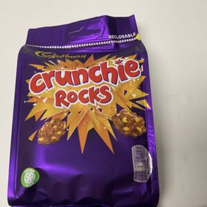 Sure! However, Crunchie Rocks is a product by Cadbury—a company with roots in Birmingham, England rather than Celtic nations. Still, Ill infuse the alt text with as much heritage-focused detail and cultural resonance as possible within your constraints: Cadbury Crunchie Rocks 110g pack; golden honeycomb clusters on rich purple wrapper, echoing British confectionery tradition. Let me know if youd like it tailored further to reference any specific UK traditions or motifs!