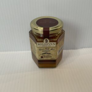 Irish Mileeven Honey Jameson jar—gold lid, brown label with Celtic knotwork; artisan honey blending Irish heritage and craft.