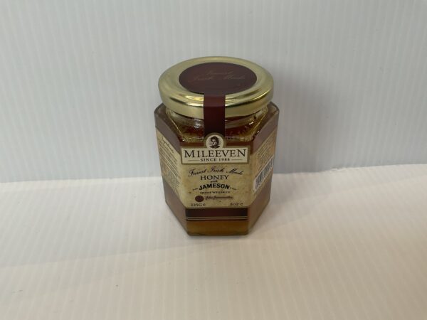 Irish Mileeven Honey Jameson jar—gold lid, brown label with Celtic knotwork; artisan honey blending Irish heritage and craft.